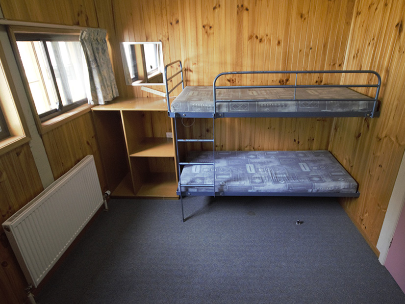 A bunk room at Howmans Gap Alpine Centre with two beds.