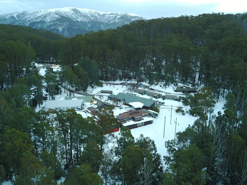 An aerial image of Howmans Gap Alpine Centre during the winter snowfall.