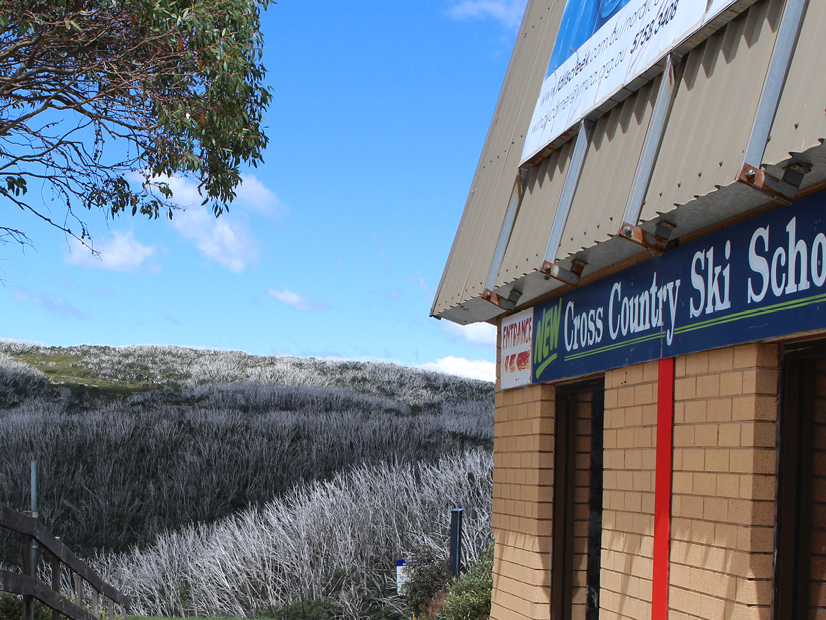 Outdoor Signage which reads "Cross Country Ski School" on a brick building.